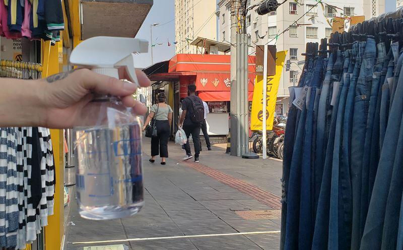 Aplicação de álcool em clientes de loja no Centro