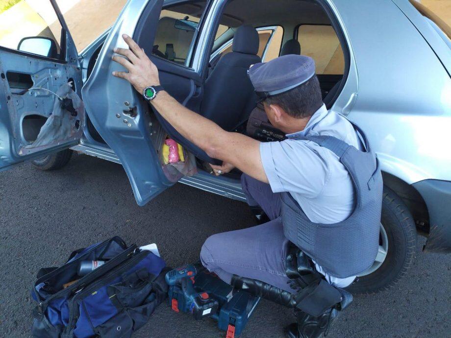 Policial retirando droga de automóvel apreendido com foragido. Foto: Divulgação