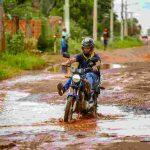 Motociclista precisa levantar as pernas para não se molhar ao transitar pela via