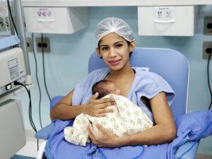 Vanessa com um dos bebês. Ela precisa de doação de fraldas e de leite em pó para recém-nascidos | Foto: Divulgação