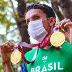 Campeão paralímpico exibindo as medalhas de Tóquio na concentração para carreata no Horto Florestal