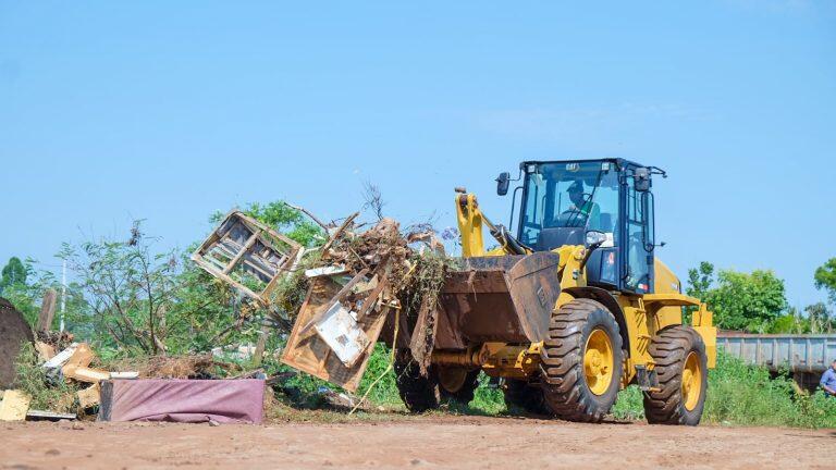 Equipes retiram lixo de terreno baldio