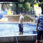 Homem tomando banho em fonte da praça Ary Coelho