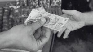 Caixa dando troco em dinheiro para cliente - (Foto: Arquivo Midiamax)