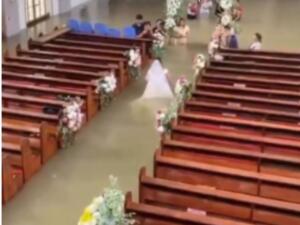 Água sobe dentro de igreja, mas casal não desiste e se casa durante enchente nas Filipinas