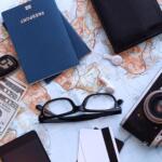 Passaporte, mapa, dólares e acessórios organizados para uma viagem.